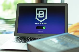 Laptop exibindo uma interface de blockchain com conexões digitais em uma tela escura.