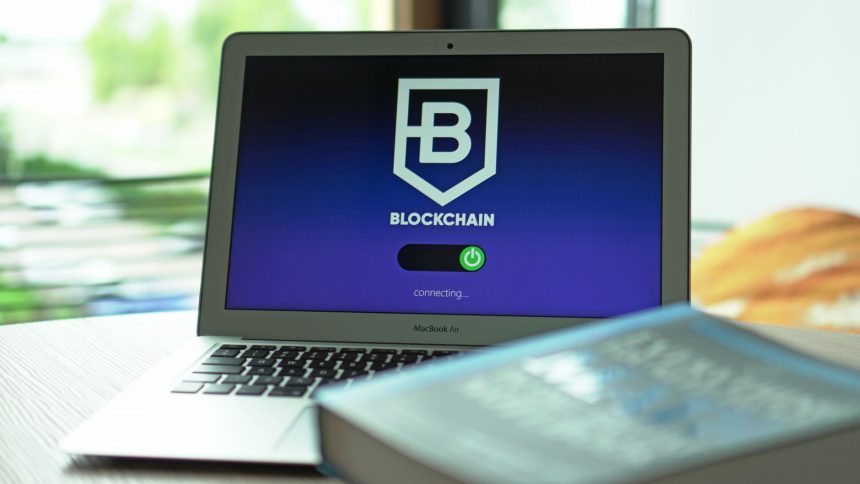 Laptop exibindo uma interface de blockchain com conexões digitais em uma tela escura.
