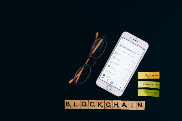 Smartphone exibindo informações do mercado de criptomoedas sobre fundo escuro, associado à tecnologia blockchain.