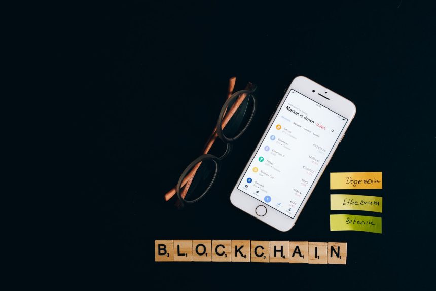 Smartphone exibindo informações do mercado de criptomoedas sobre fundo escuro, associado à tecnologia blockchain.